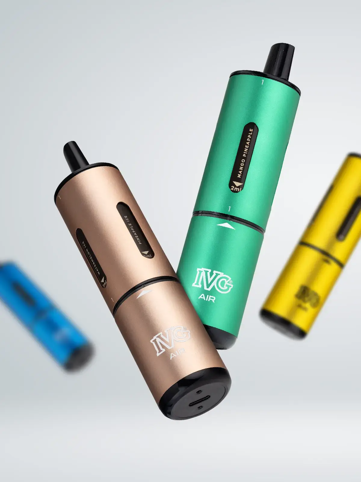 Four colours of the IVG Air 4-in-1 disposable vape; Pink Edition, Blue Edition, Green Edition and Yellow Edition, all floating in front of a white background with some out of focus.