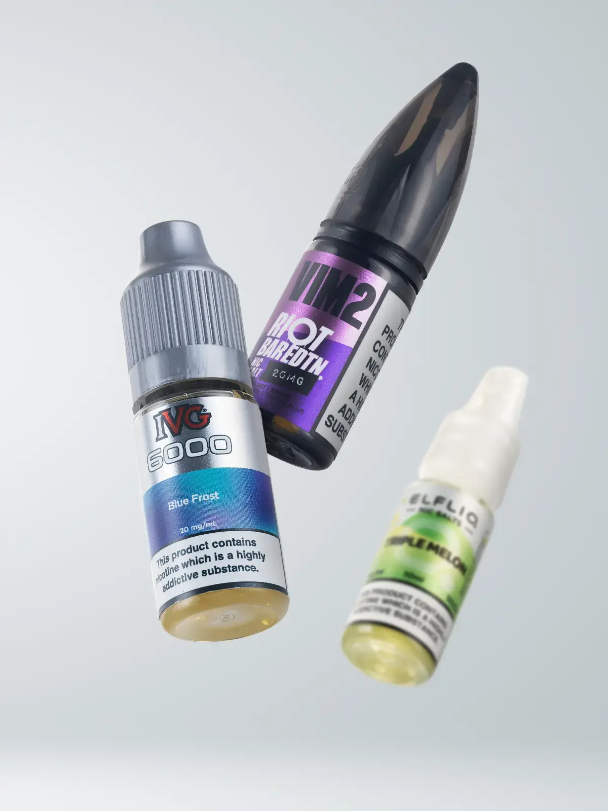 Three bottles of 10ml e-liquid; Elfliq, Riot Bar Edtn and IVG 6000. Floating in front of a light grey background.