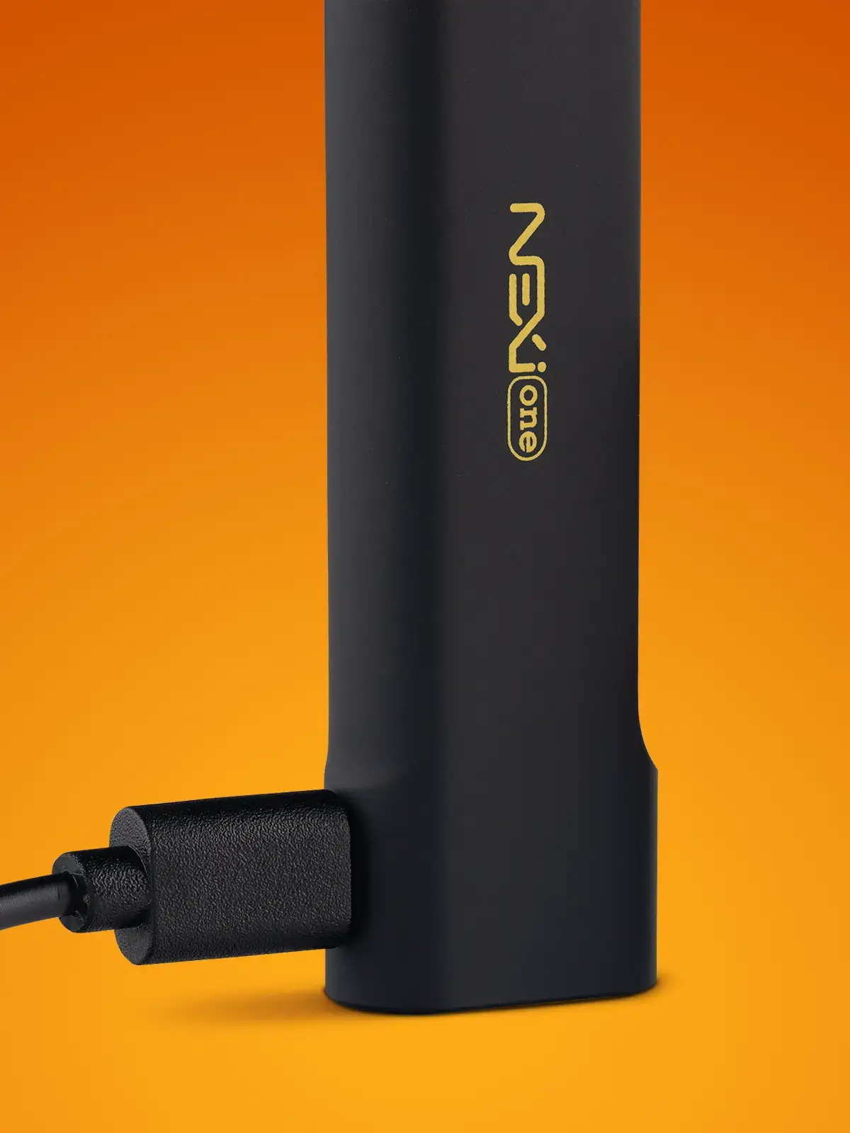 A close-up of the Aspire Nexi One kit, showing a USB-C cable plugged in. Orange background.