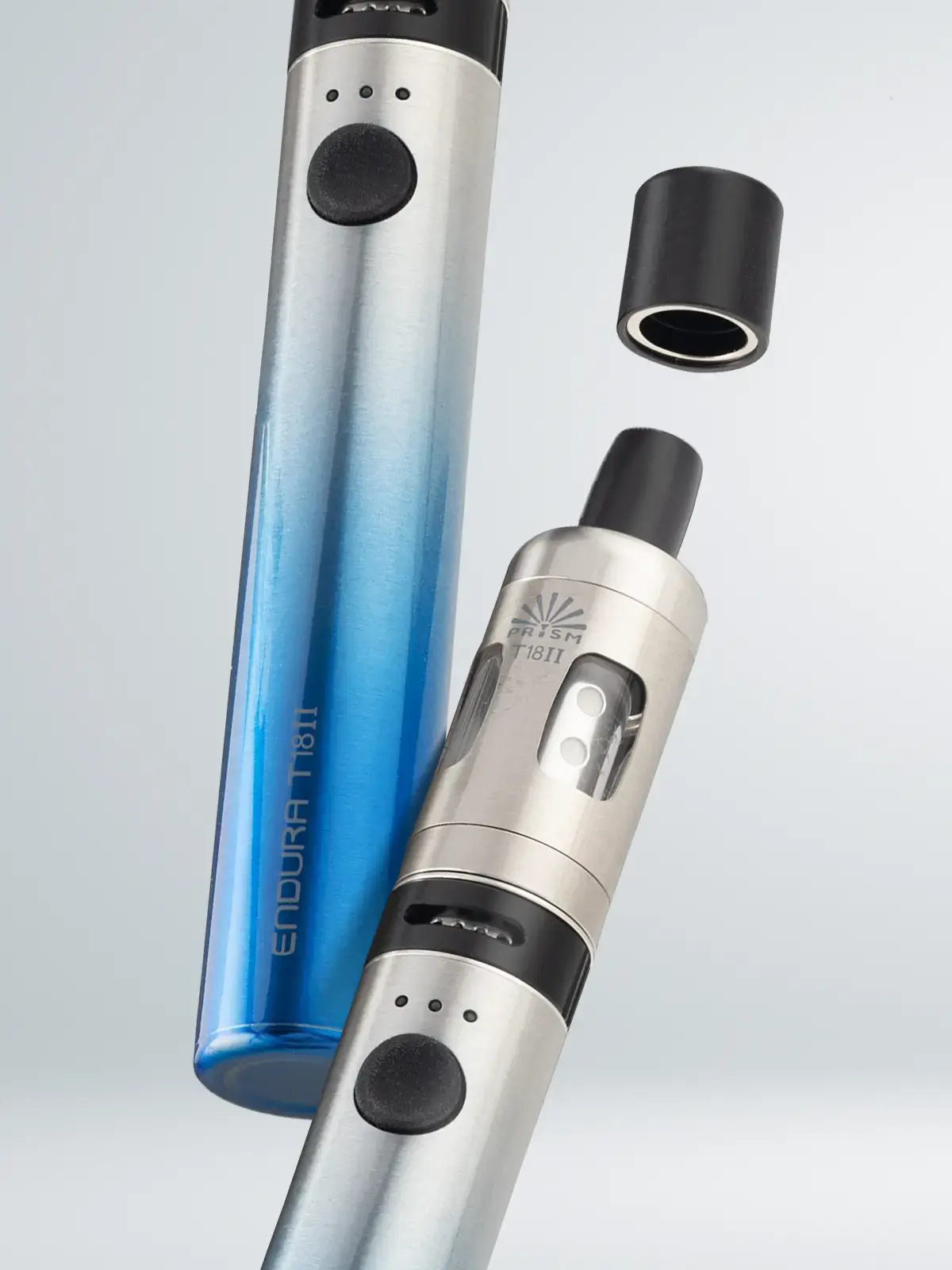 Two Innokin Endura T18 II devices, floating in front of a light background. The silver device is shown with its drip tip cap off, demonstrating that you can keep the mouthpiece free of dirt and debris.